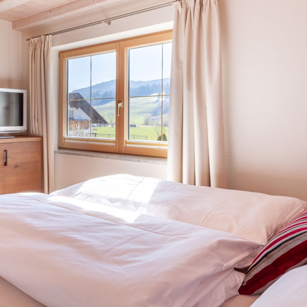 Schlafzimmer mit Blick aus dem Fenster auf die Landschaft