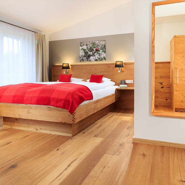 Doppelbett mit Holzrahmen und weißen Kissen