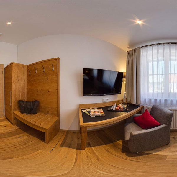 Zimmeransicht mit Fernseher, Schreibtisch und Garderobe