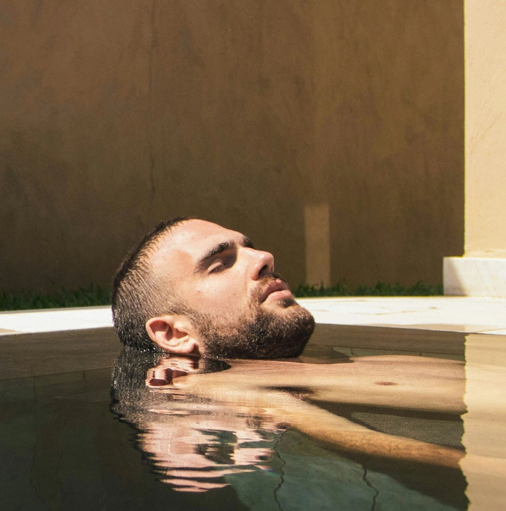Mann entspannt im Pool im Wellnessbereich