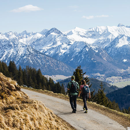 Wanderer auf einem Bergweg mit Blick auf die Allgäuer Alpen