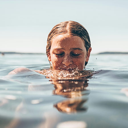 Frau taucht entspannt im Wasser beim Day Spa