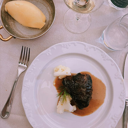 Fleischgericht mit Sauce und Beilagen auf einem Teller